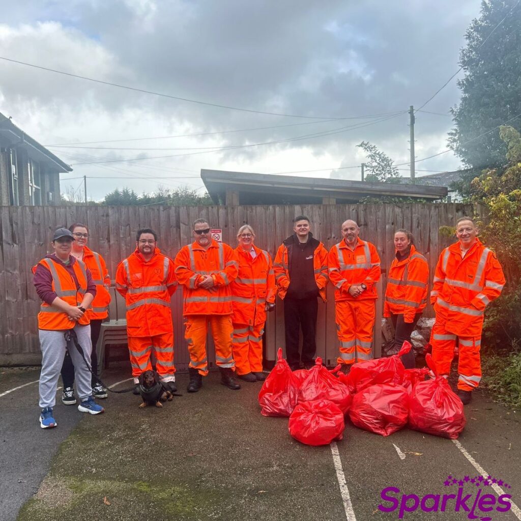 Workers dressed in orange after a litter pick for a tidier community